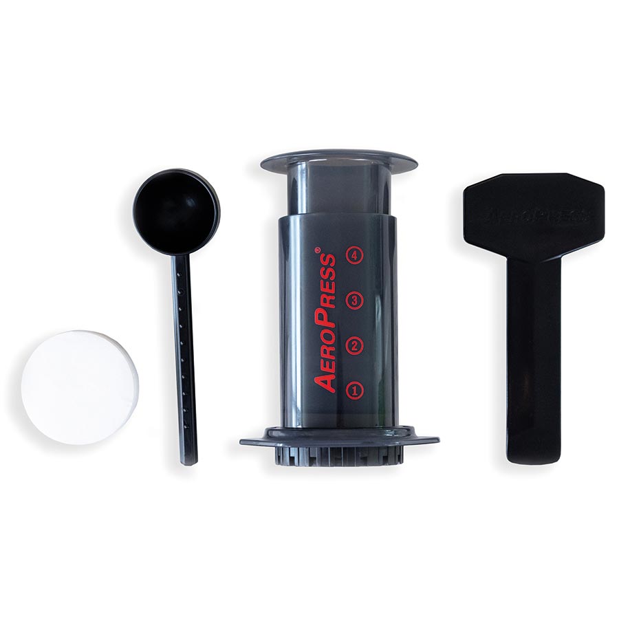 AeroPress coffee maker with a measuring scoop and a stirrer, alongside a filter cap.