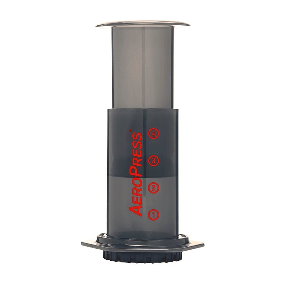 AeroPress coffee maker with a measuring scoop and a stirrer, alongside a filter cap.