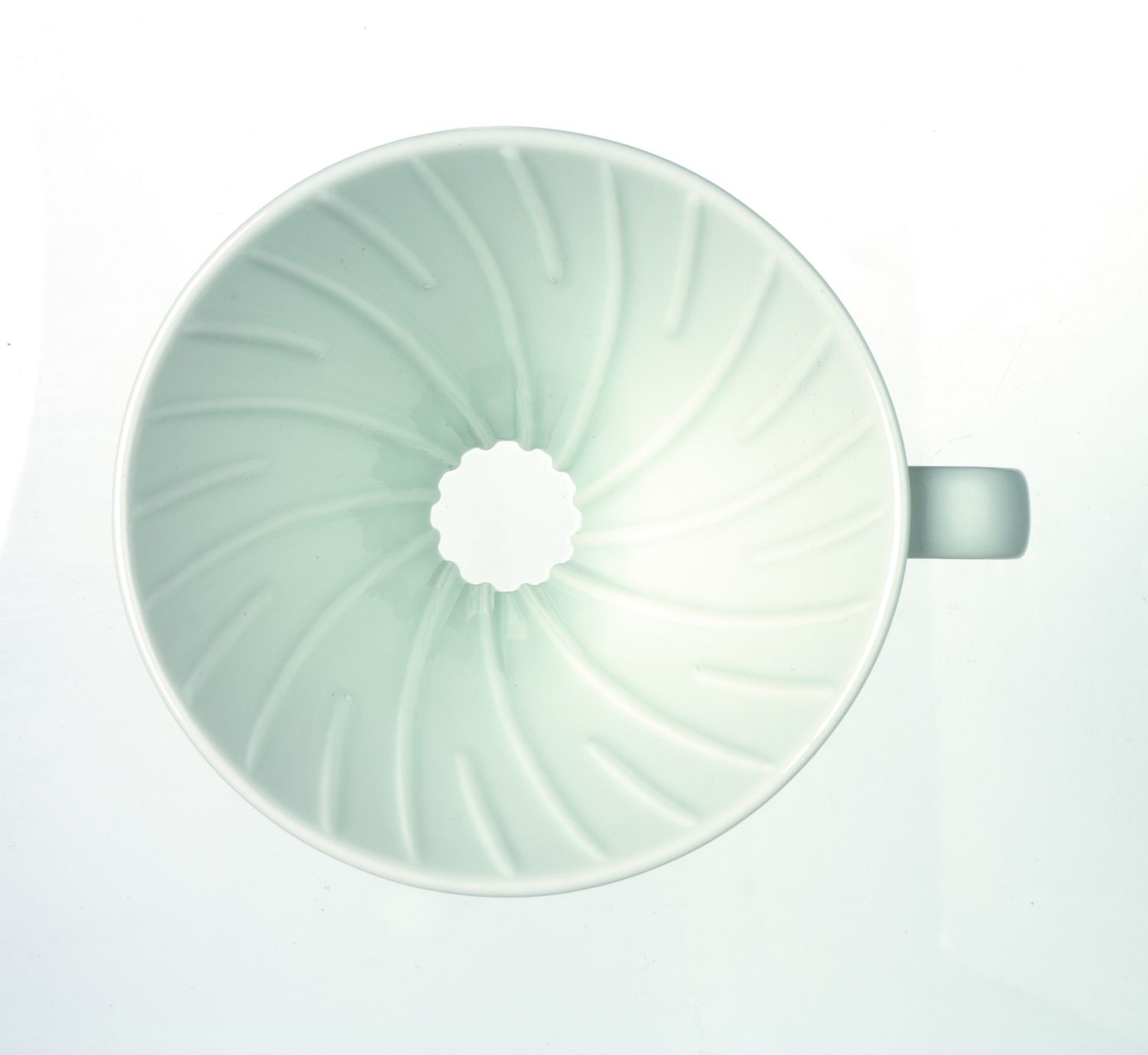 Top view of a light green ceramic cup with a spiral interior design.